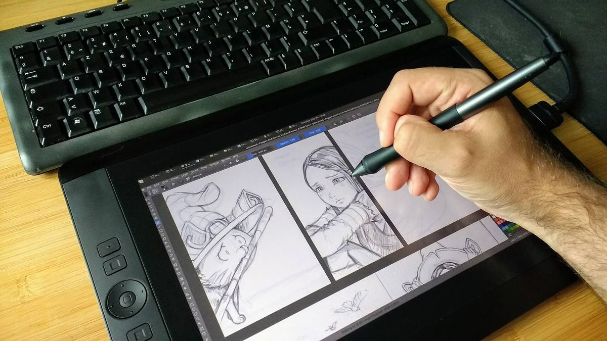 Člověk kreslí perem na grafickém tabletu
