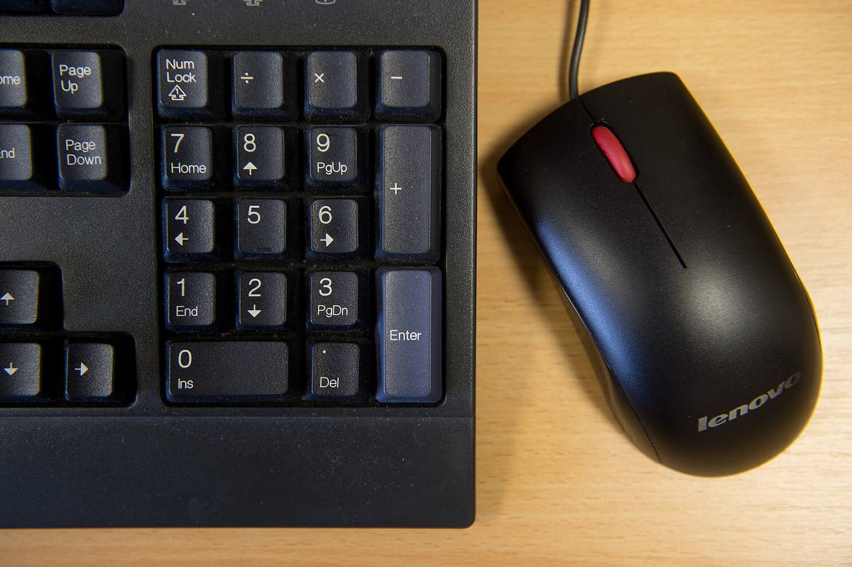 Klávesnice Lenovo a počítačová myš na stole