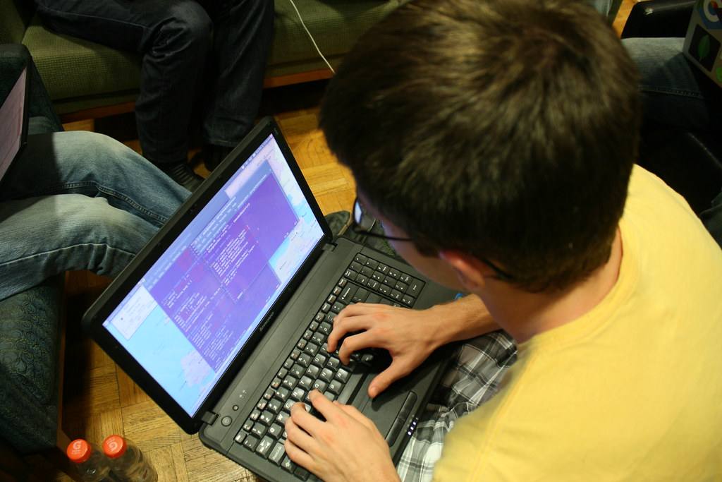 Programátor pracuje na notebooku během studentského hackathonu