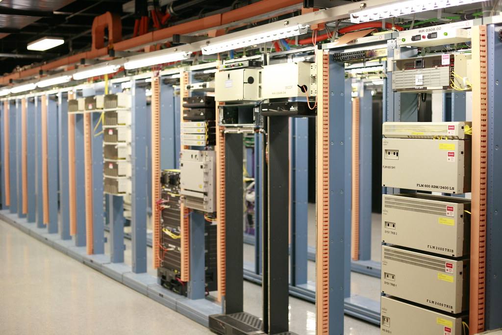 Řada stojanů s telekomunikačním a serverovým vybavením v datovém centru