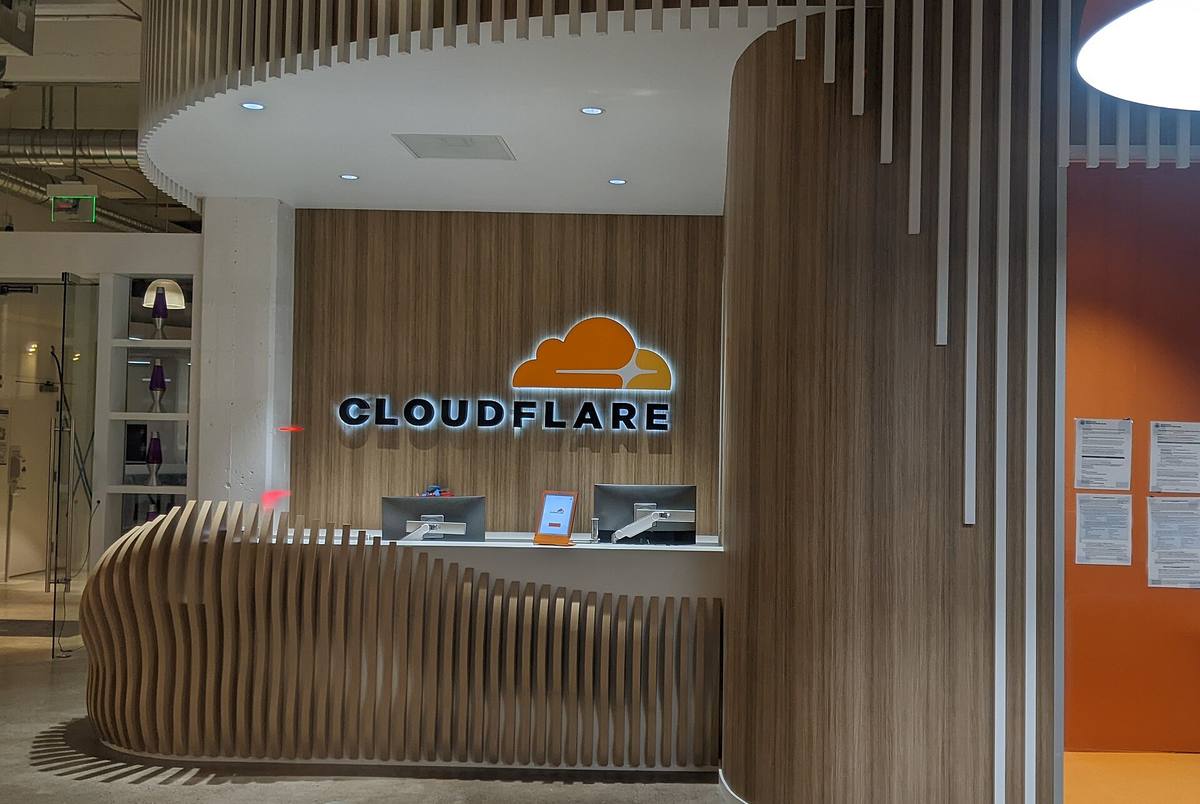 Recepce kanceláří Cloudflaru s logem firmy na dřevěné stěně