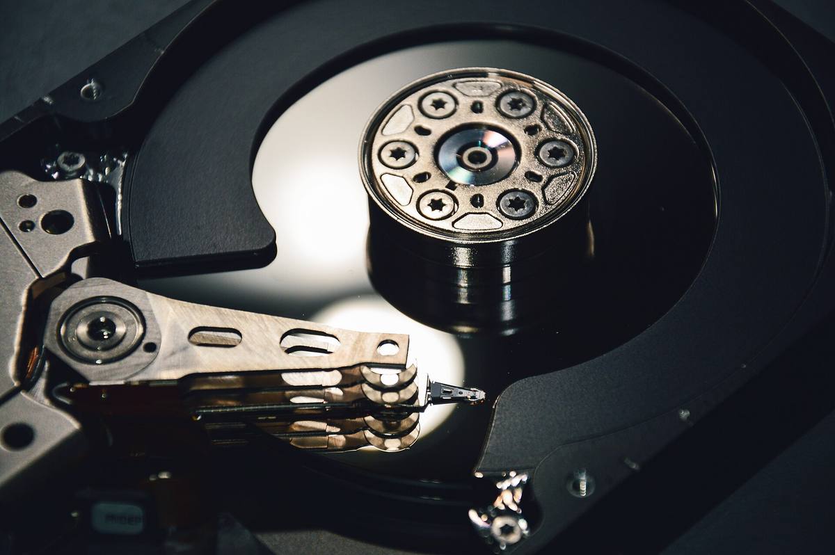 Otevřený pevný disk s odkrytými plotnami a čtecím ramenem