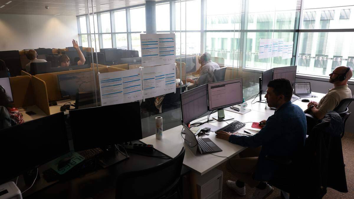 Pracovníci telefonního centra u počítačů se sluchátky